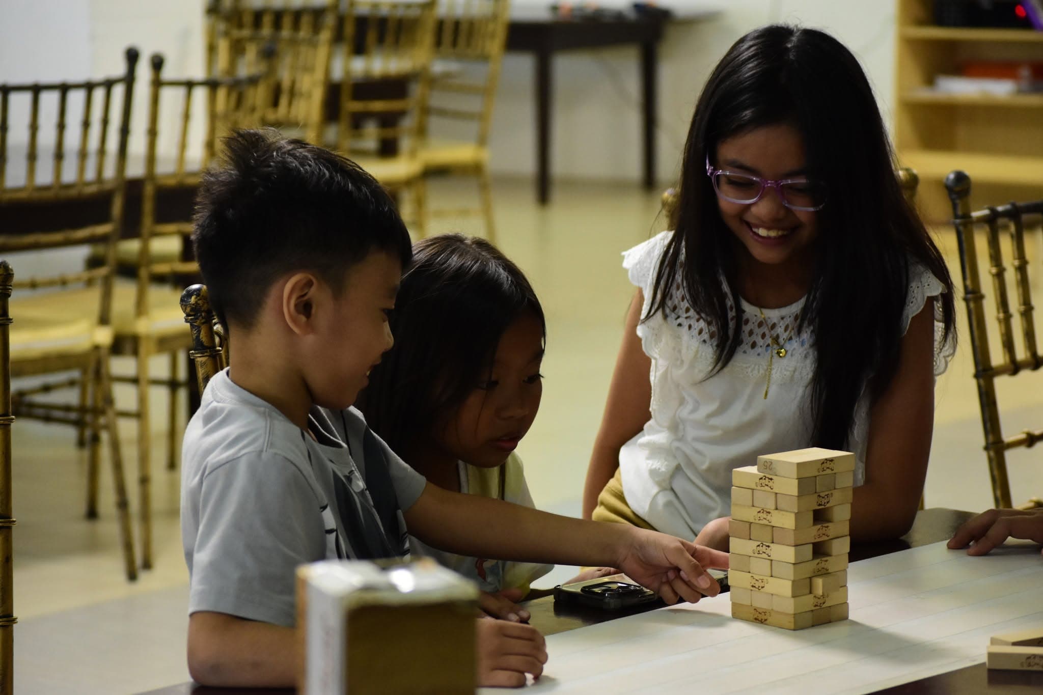Children playing a table game together at the PBCi Children's Camp.