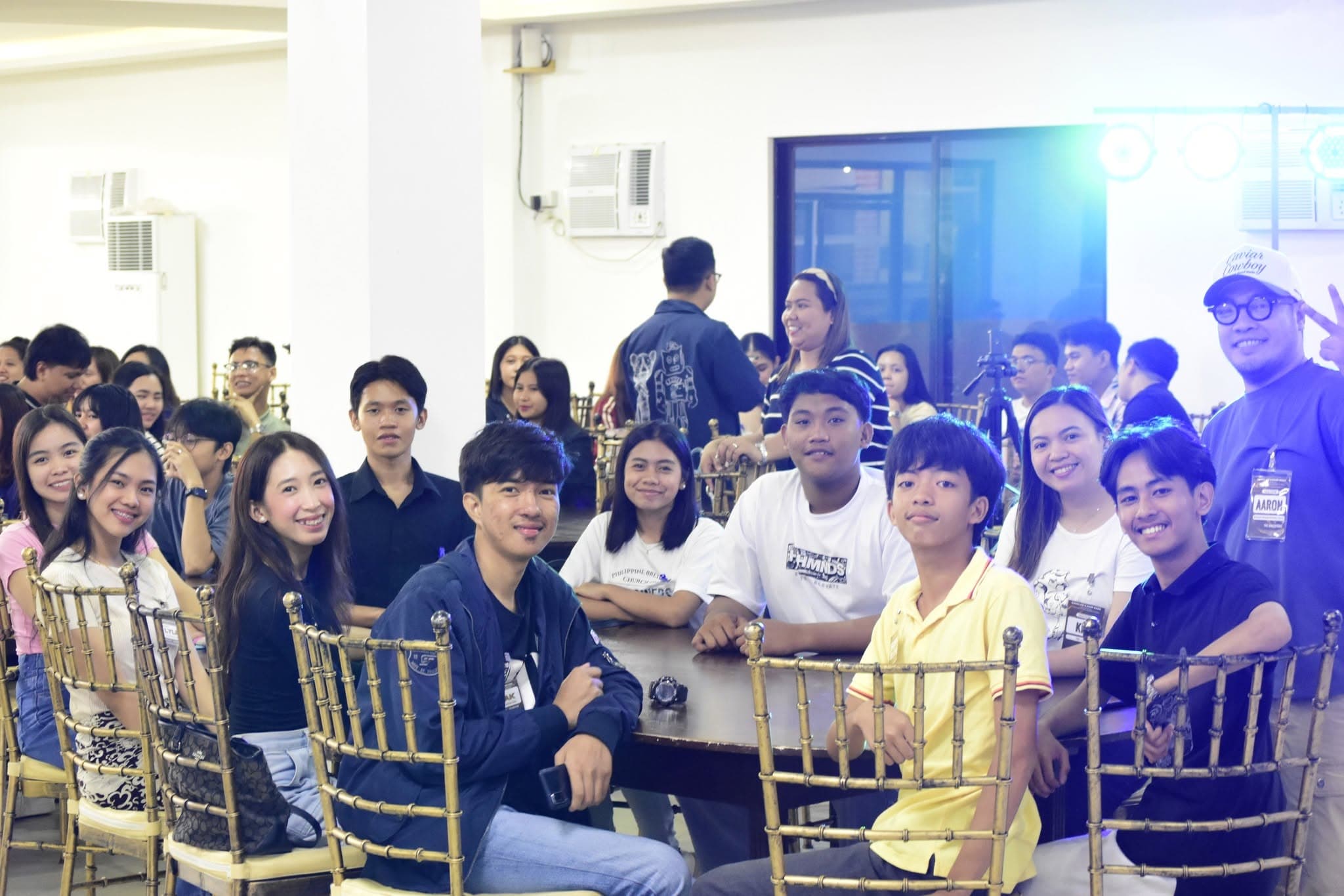 Young adults seated around a table at the PBCi Singles' Camp.